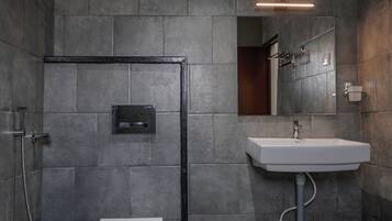 A modern bathroom with a toilet, bidet, and sink.