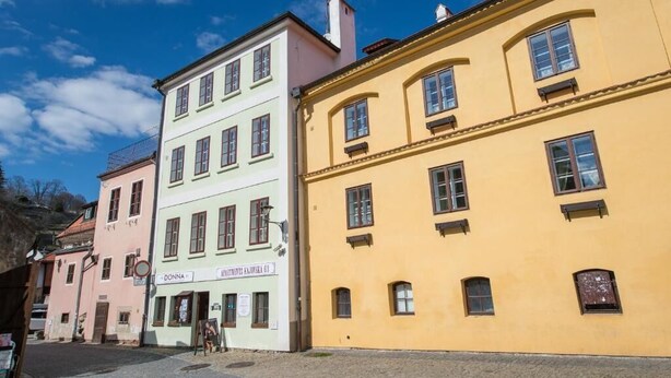 En rad färgglada byggnader med en skylt där det står ”Donna” och ”AIMUNTE RAJNA 63”.