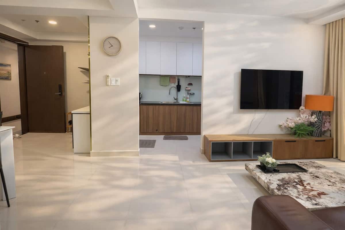 Un salon moderne avec un téléviseur à écran plat, une table basse et un canapé.