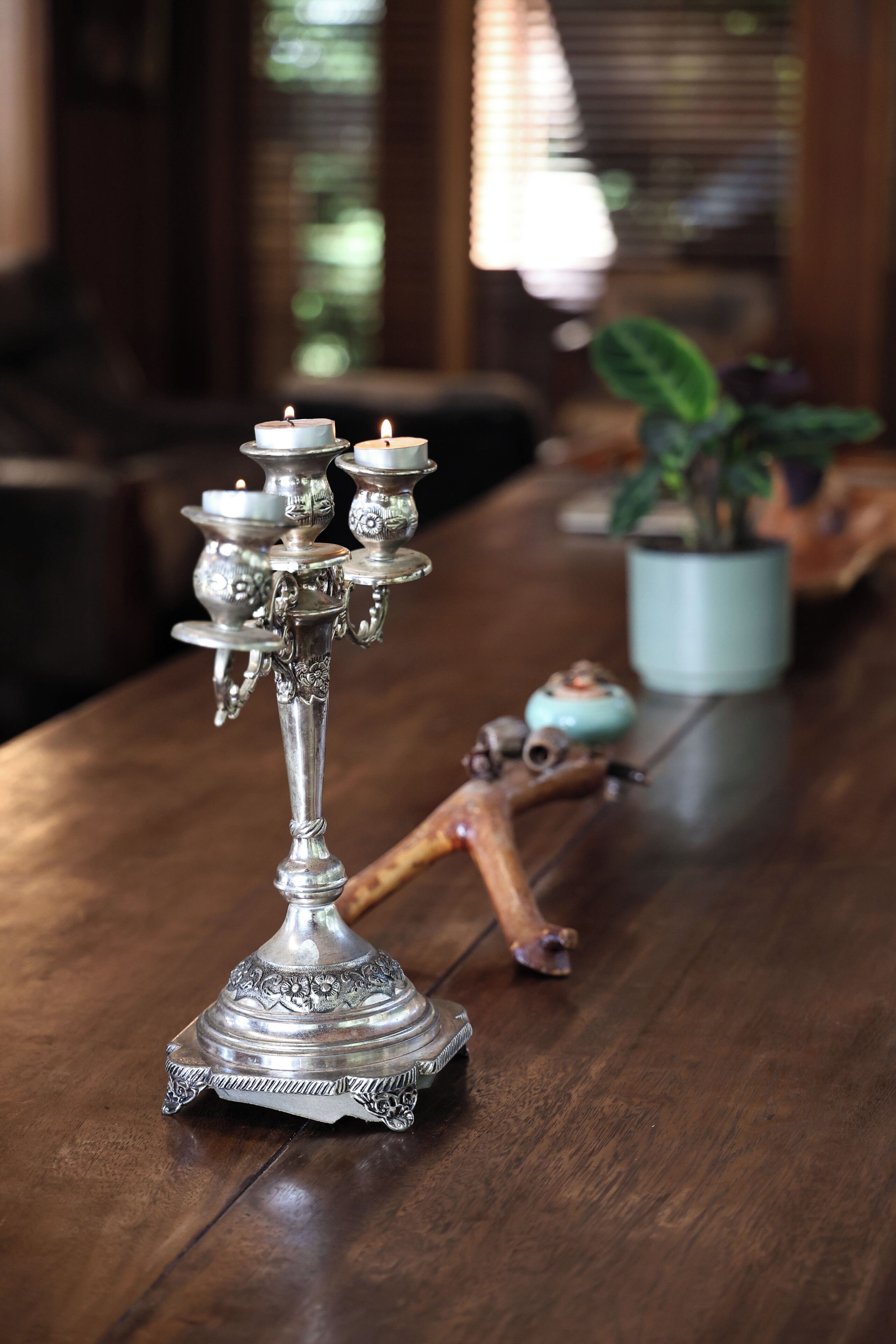 A silver candelabra with multiple candles on a wooden table.