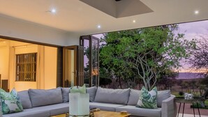 Ein modernes Wohnzimmer mit einer Couch, einem Couchtisch und Blick auf Bäume.