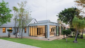 Ein modernes Haus mit Glaserker, einem gepflasterten Auffahrt und einem gepflegten Rasen.