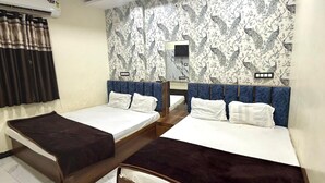 Ein Hotelzimmer mit zwei Betten, einem Deckenventilator, einer Klimaanlage und einem strukturierten Wandpapier.