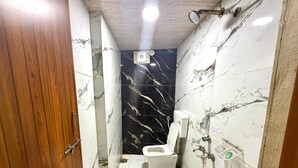 Ein Badezimmer mit Toilette, Bidet und einem grünen Eimer.