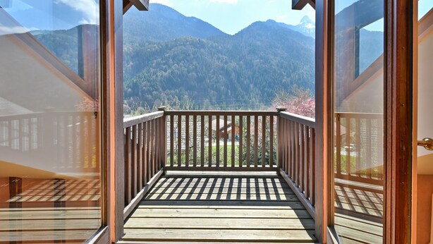 Una terraza de madera con vistas a un paisaje montañoso.