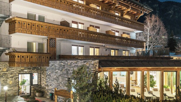 Un immeuble à plusieurs étages doté de balcons, d’une piscine et dont le sol est recouvert de neige.
