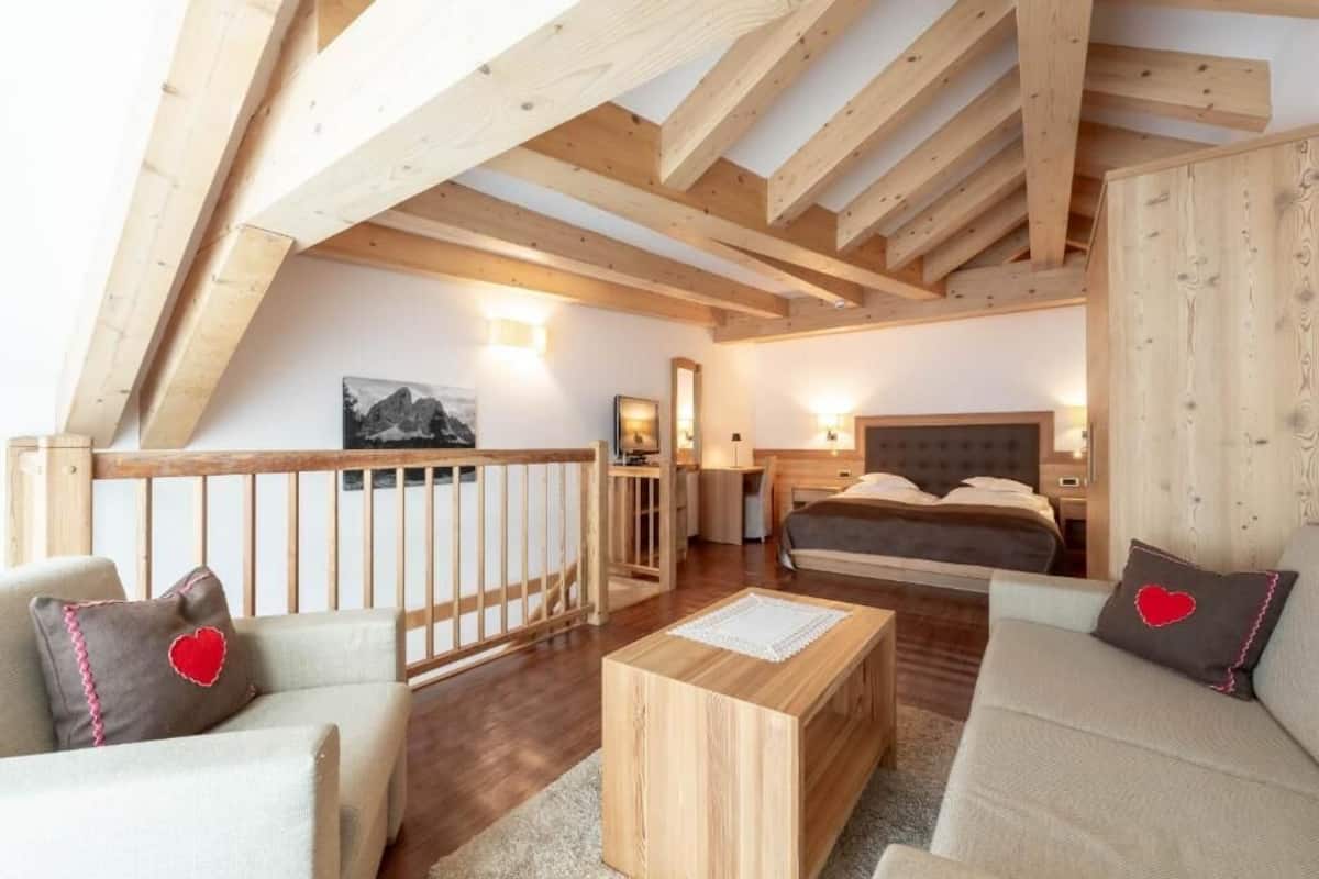 Un dormitorio con cama, mesita de noche y techo de madera.