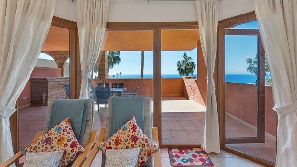 A room with two chairs, a table, and a view of the sea. - Apartment 'Estilo El Higuerón' with Sea View, Wi-Fi, and Air Conditioning (Benalmádena)