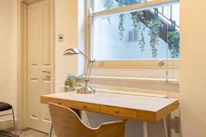A desk with a lamp, chair, and window with plants. - Chelsea 3BR Duplex Garden Terrace Walk to Tube (London)