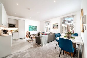 A modern apartment with a kitchen, dining area, and living room. - Earl s Court Chelsea 4BR Duplex Ap Walk to Tube (London)