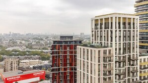 Ein modernes Hochhaus mit einem gut sichtbaren Shurgard-Selbstlagerschild, großen Fenstern und einer Skyline im Hintergrund.