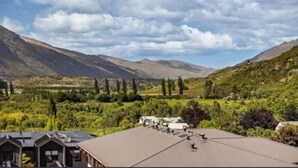 A residential area with houses, a valley, and mountains in the background. - Mountain View Exchange (Queenstown)