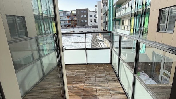 En moderne bygning med store glasvinduer og en træbalkon.