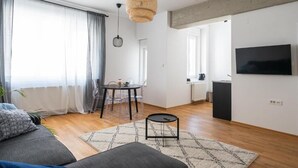 Een moderne woonkamer met een bank, eettafel en keukenhoek.