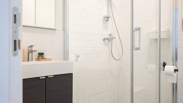 A modern bathroom with a glass shower enclosure, a white tiled floor, and a dark-colored vanity.