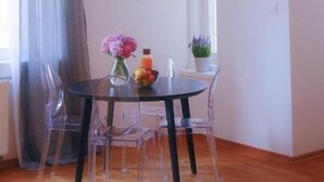 Een eetruimte met een tafel, stoelen en hanglampen.