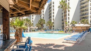 A poolside area with lounge chairs, a bar, and a pool. - Saida Royale 145 - Premier Location with Breathtaking Ocean Views. The Only Thing Missing is You! (South Padre Island)