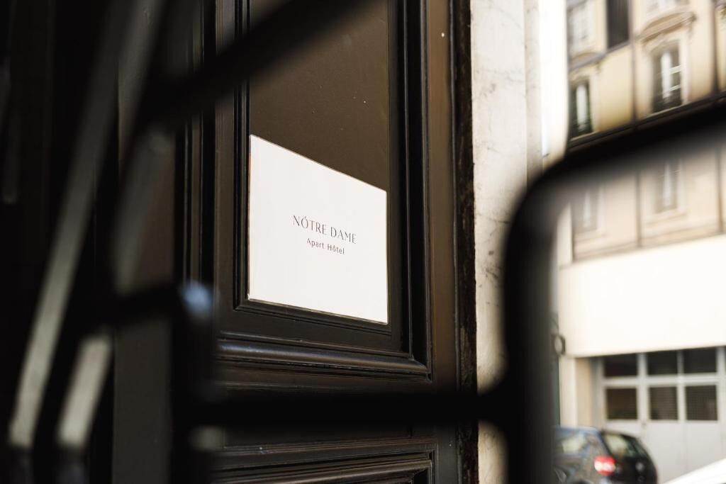 A sign with 'NÔTRE DAME part Hôtel' text, indicating a hotel section.