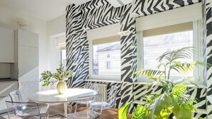 Une cuisine moderne avec des armoires blanches, un plan de travail blanc et un four encastré.
