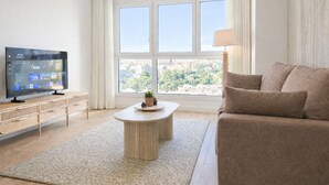 Un salon moderne avec un téléviseur à écran plat, une table basse ronde et un canapé.