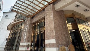 A modern hotel with a glass facade, a covered entrance, and a prominent vertical design. - Island Heart Sun Moon Lake Hotel (Yuchi)