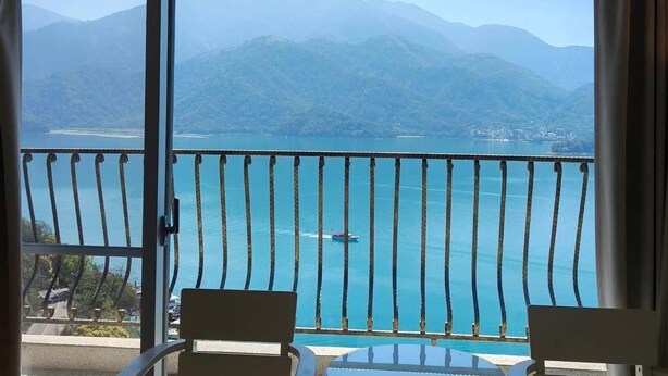 A balcony with a view of a lake, mountains, and a distant shoreline. - Island Heart Sun Moon Lake Hotel (Yuchi)