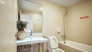 A bathroom with a toilet, sink, mirror, shower, and a potted plant. - Island Heart Sun Moon Lake Hotel (Yuchi)