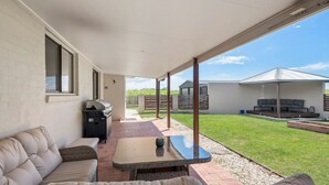 An outdoor patio with a sofa, a glass-top table, and a barbecue grill. - Robins Place - Pet Friendly River Retreat (Empire Vale)