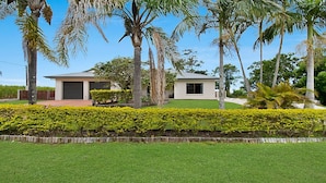 A modern two-story house with a well-maintained lawn and palm trees. - Robins Place - Pet Friendly River Retreat (Empire Vale)