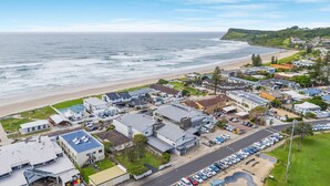 Un área residencial costera con casas, una playa y vista al océano.