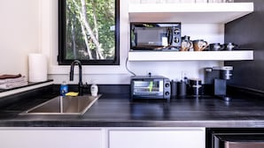 Eine moderne Küche mit integriertem Mikrowellenherd, Kaffeemaschine und Toaster.