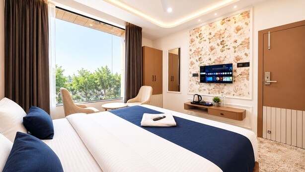 A modern hotel room with a large bed, a desk, a TV, and a view of the outdoors. - Velar Prime Hotel, Vijay Nagar, Indore (Indore)
