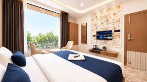 Une chambre d’hôtel moderne dotée d’un grand lit, d’un bureau, d’une télévision et offrant une vue sur l’extérieur.