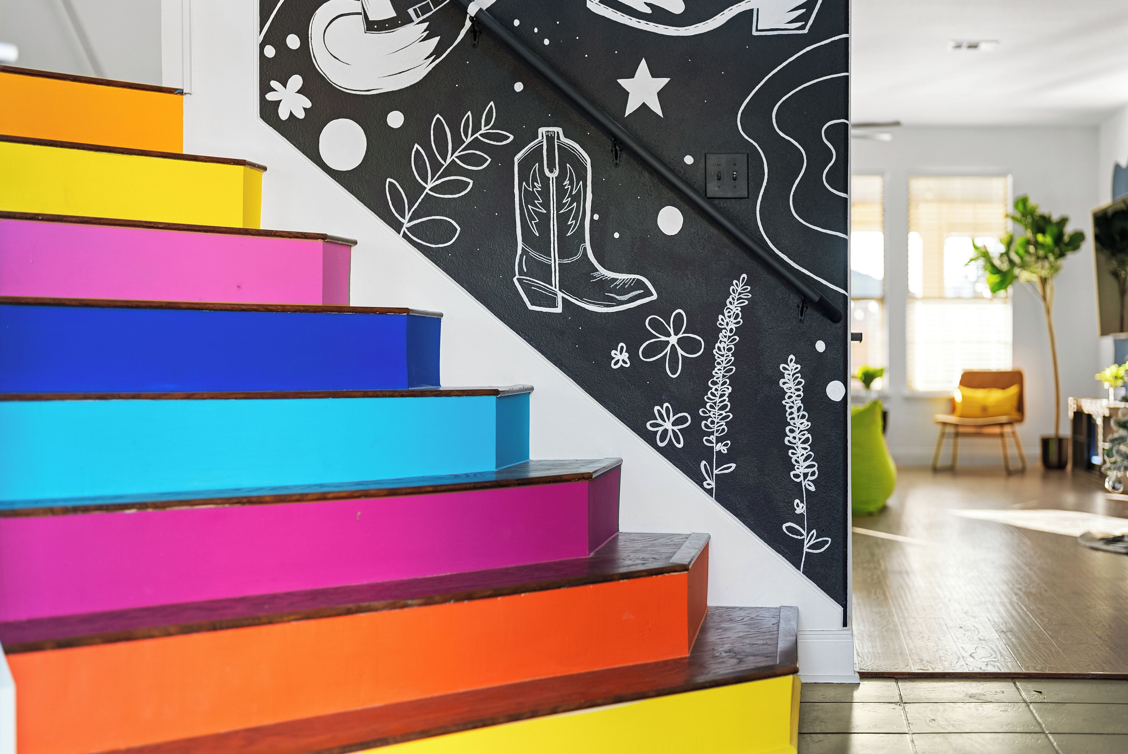 A staircase with colorful steps and a wall with decorative elements.