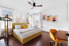 A bedroom with a bed, a desk, a chair, a ceiling fan, and artwork on the wall. - Grand 6BR 3BA Pool Escape Round Rock (Round Rock)