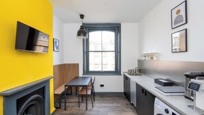 Una cocina compacta con horno integrado, microondas y cafetera.