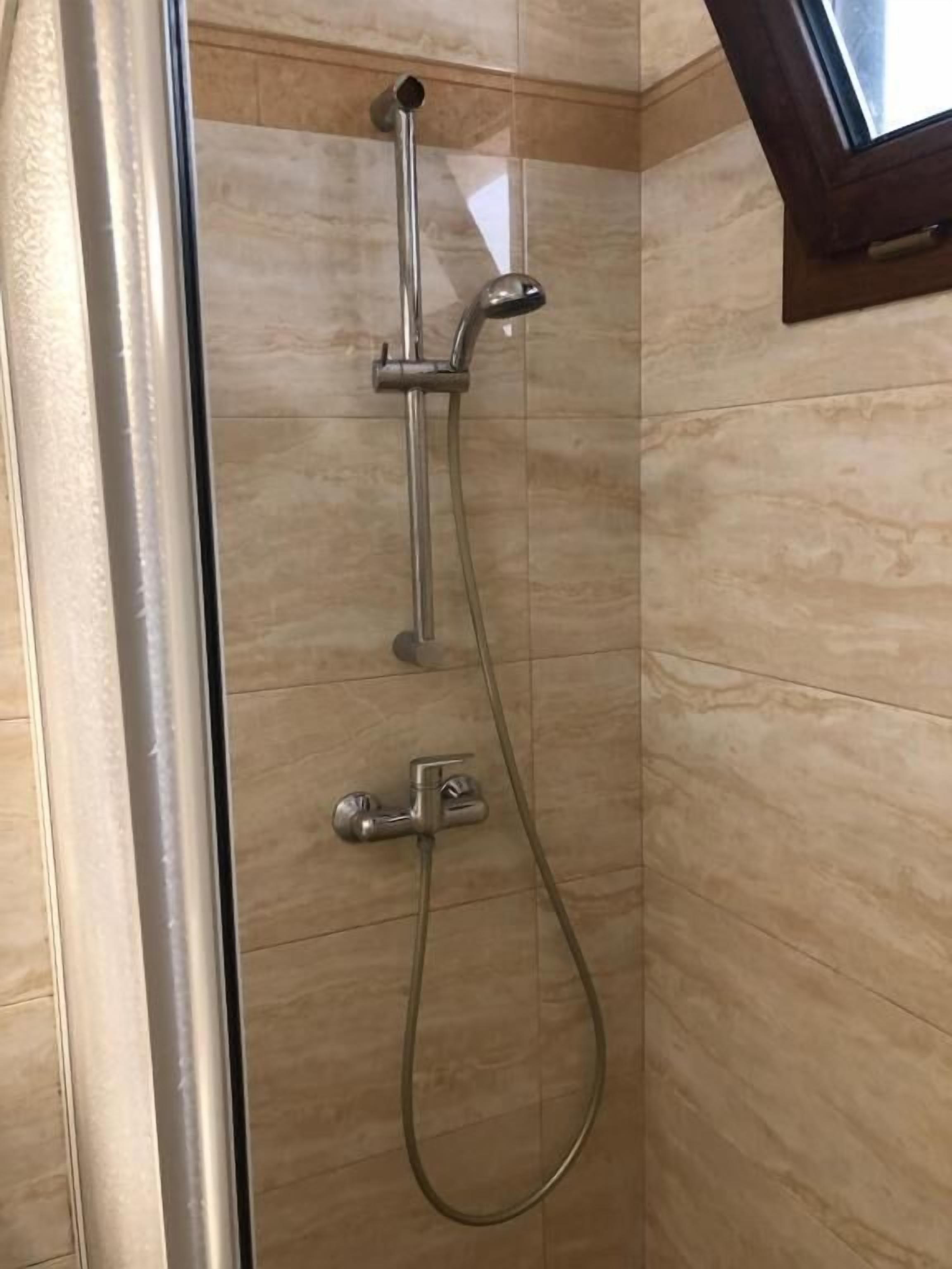 Ducha con cabezal de ducha y grifo de mano.