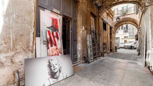 A narrow alleyway with a vintage building, a ladder, and a large framed picture on the wall. - La Galleria - Piazza di Spagna (Rome)