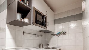 A modern kitchen with a microwave, sink, and cabinets. - La Galleria - Piazza di Spagna (Rome)