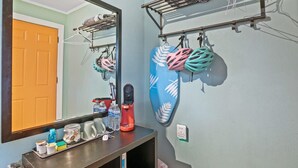 A bathroom with a mirror, a towel rack, a shelf with toiletries, and a wall-mounted bike rack. - Travel Back to the 50s- Renovated Motel Gem (St. Augustine)