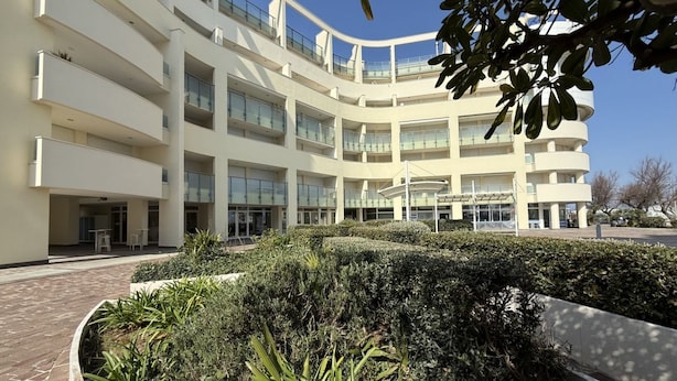 A multi-story building with balconies, a courtyard with plants, and a clear sky. - SE219 - Senigallia, two-bedroom apartment with a beautiful seafront terrace (Senigallia)