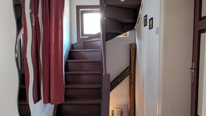 Un escalier avec des marches en bois et un rideau rouge.
