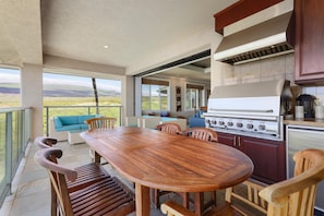 An outdoor kitchen with a large grill, dining table, and chairs. - Amazing Ocean, Mountain & Golf Views, Beautiful Ocean Villa (Kamuela)