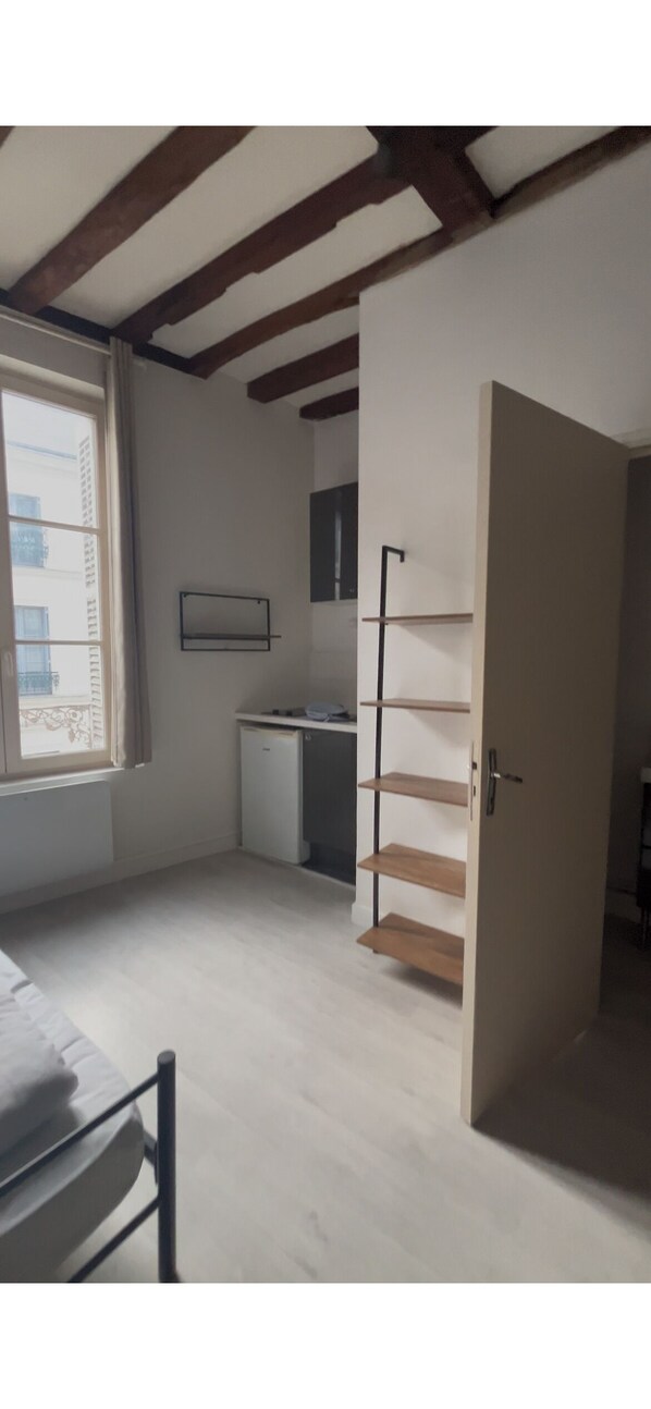 Une pièce comprenant un lit, un bureau, une armoire et une fenêtre.