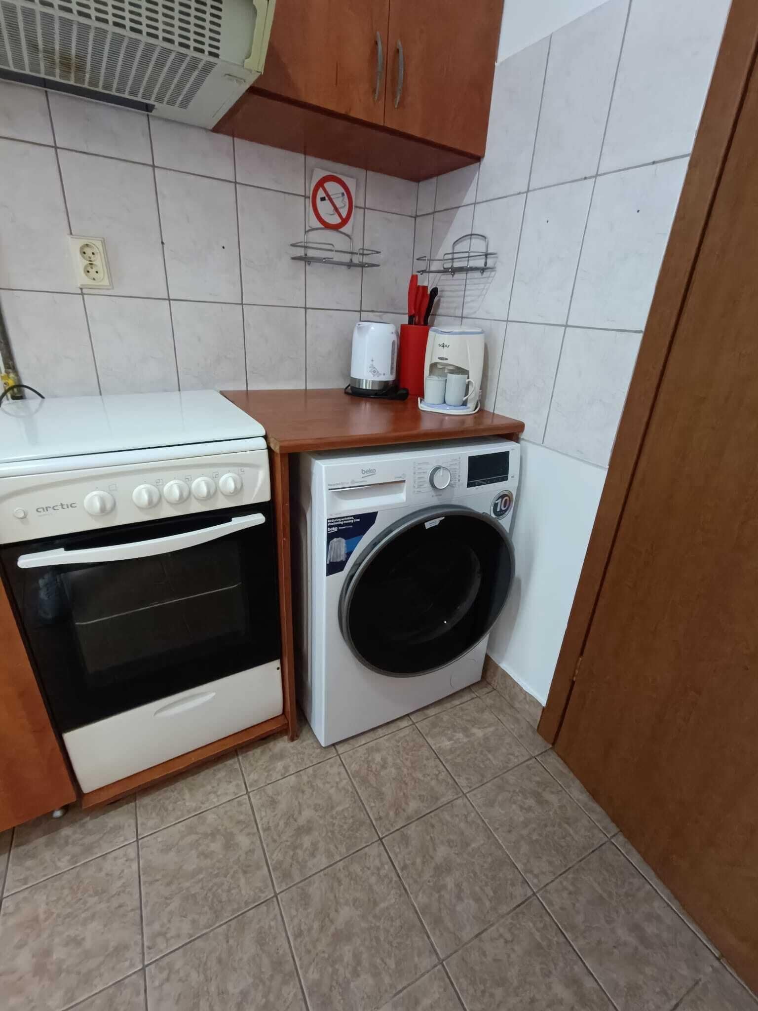 A compact kitchen with a stove, oven, and washing machine.