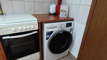 A compact kitchen with a stove, oven, and washing machine.