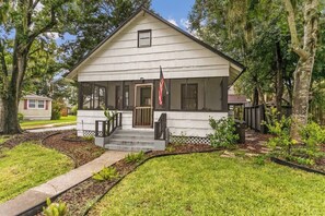 A single-story house with a porch, a front door, and an American flag. - Cozy Bungalow Near Shops-st Augustine (St. Augustine)