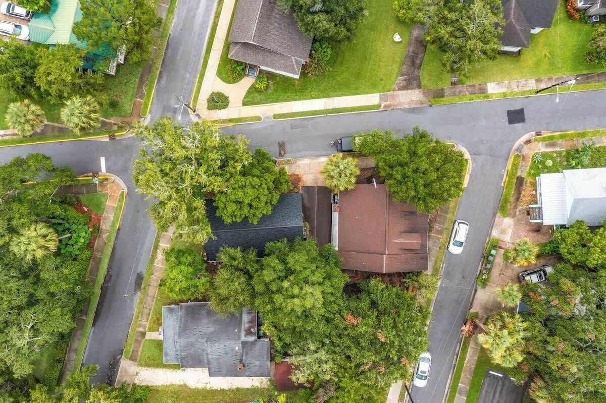 An aerial view of a residential area with houses, roads, and greenery.