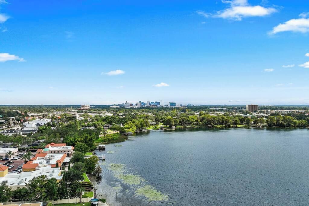 A cityscape with a large body of water, buildings, and greenery.