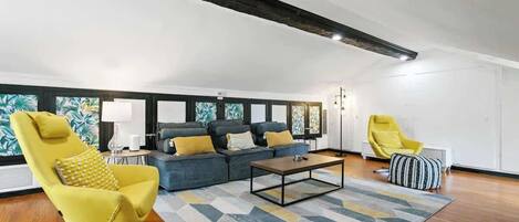 A modern living room with a sofa set, a yellow armchair, a coffee table, and a patterned rug.